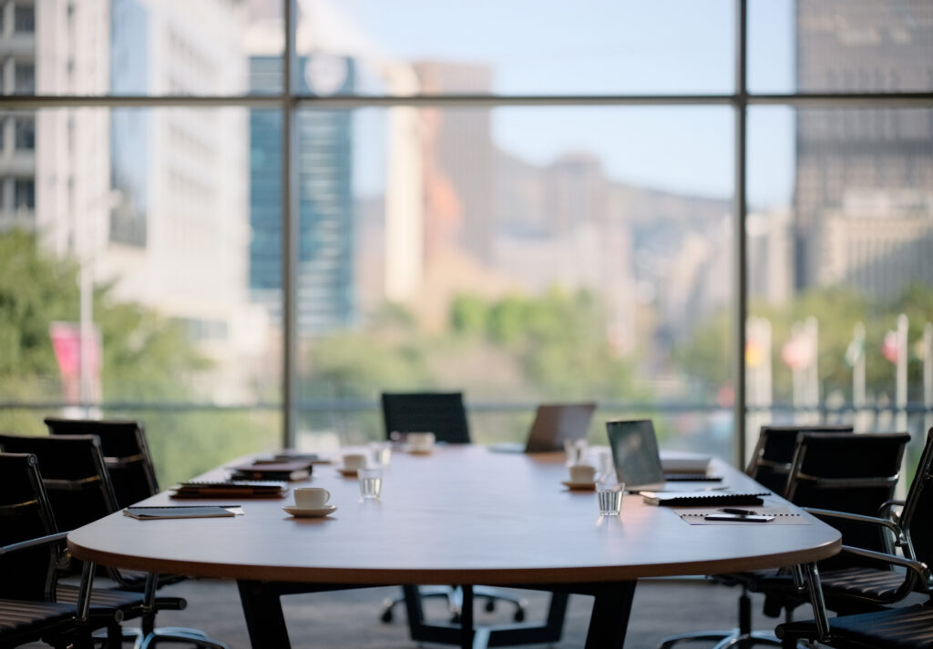 An empty meeting room in a coworking space, with chairs, tables, coffee, and technology.